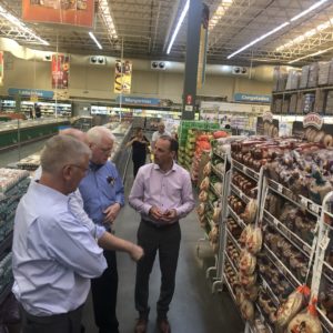 Trade mission attendees in the local grocery store discussion various products
